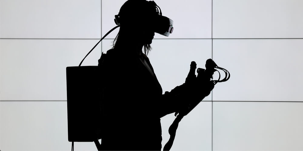 Silhouette of female Lowes Innovation Labs team member wearing haptics enabled gloves with tactile feedback. 