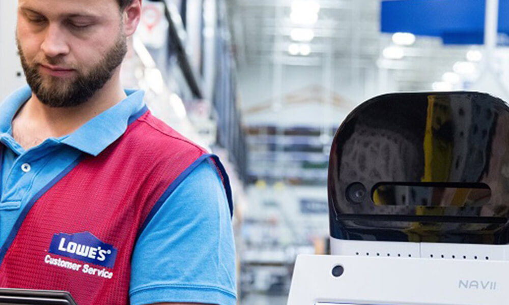 Male Lowe's Home Improvement store associate programming a LoweBot. 